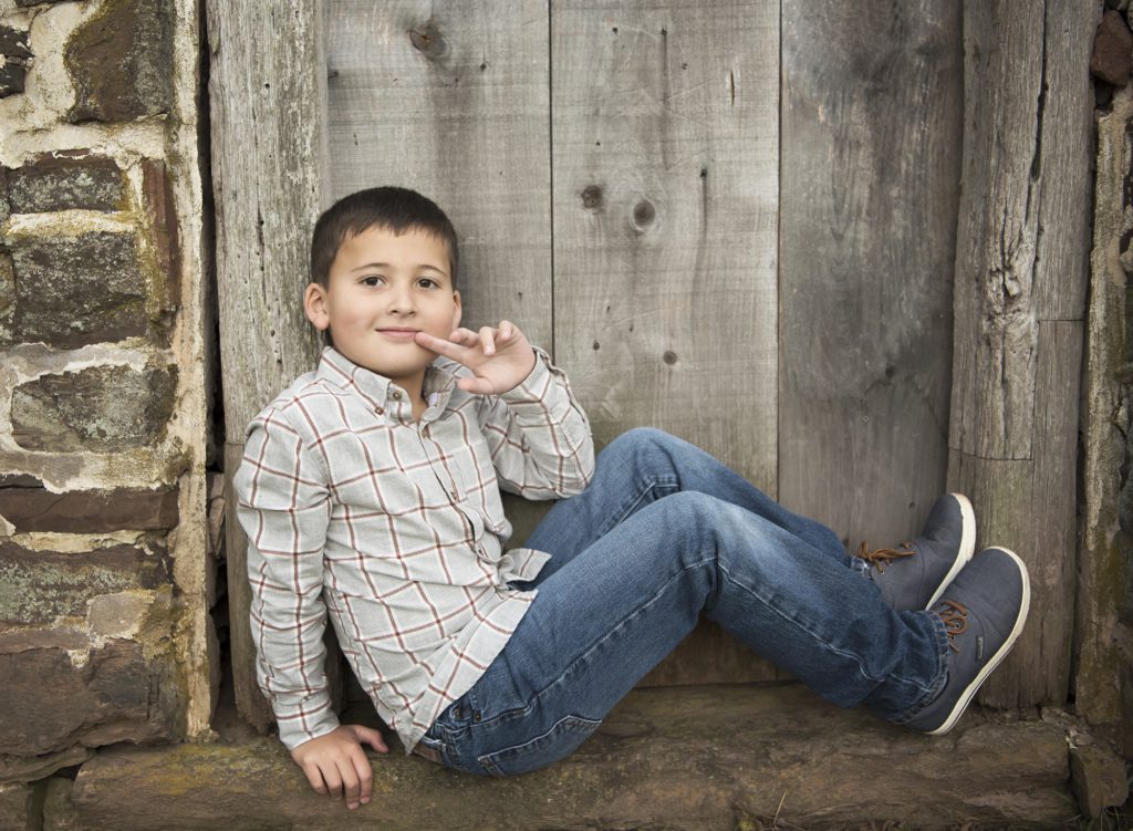 boy_sitting_on_ledge_in_front_of_heckler_plains_farmstead