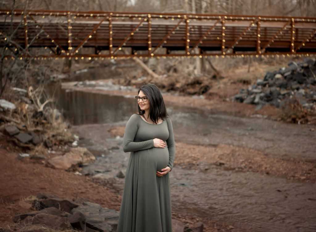 Maternity_portrait_session_pregnant_mom_holding_belly_creek_bridge_rocks_fischers_park_maternity_lansdale.jpg