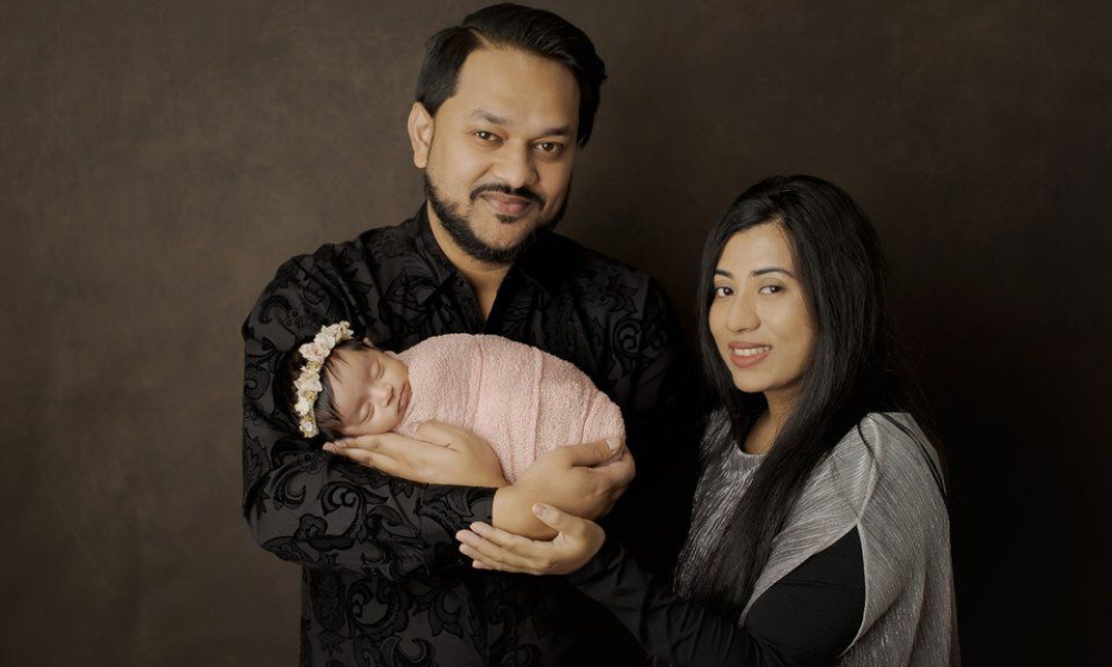 Dad holding Newborn baby with his wife
