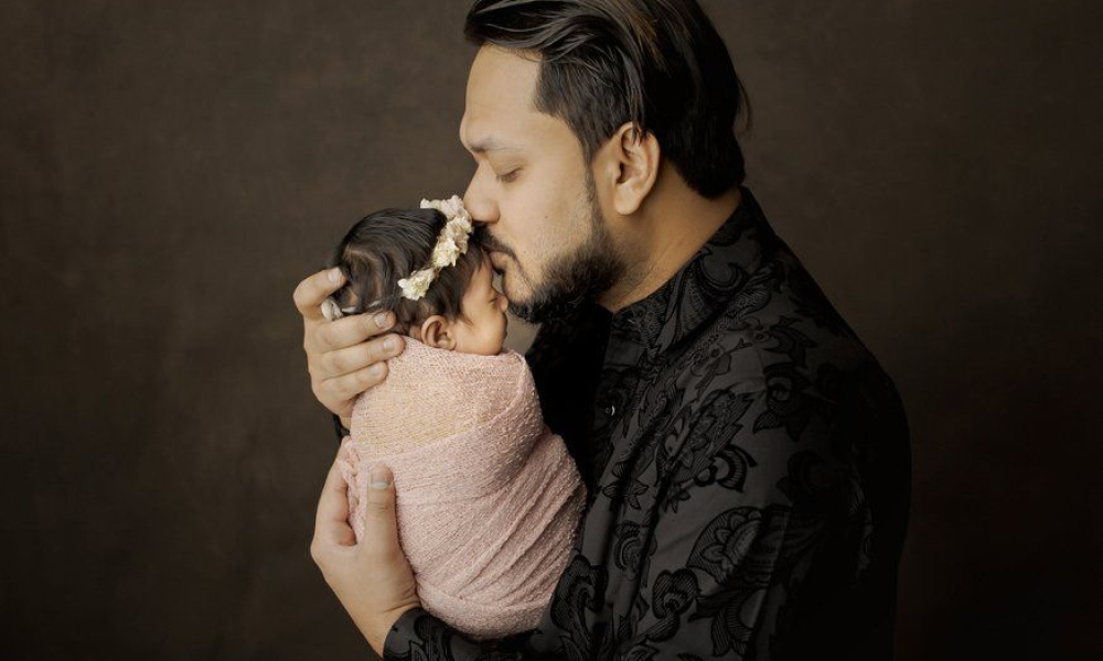 Dad kissing newborn baby forehead