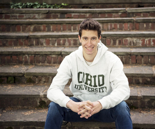 High School Senior sitting in brick steps wearing Ohio University shirt at Highland Mansions in Ft. Washington Lansdale family and newborn photographer