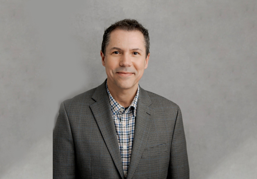Professional headshot of A man in check shirt and checkard suit jacket Lansdale