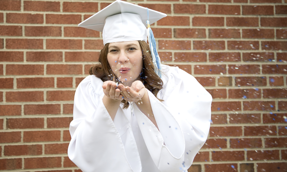 senior-portraits-girl-cap-gown-blowing-confetti-lansdale-family-photographer