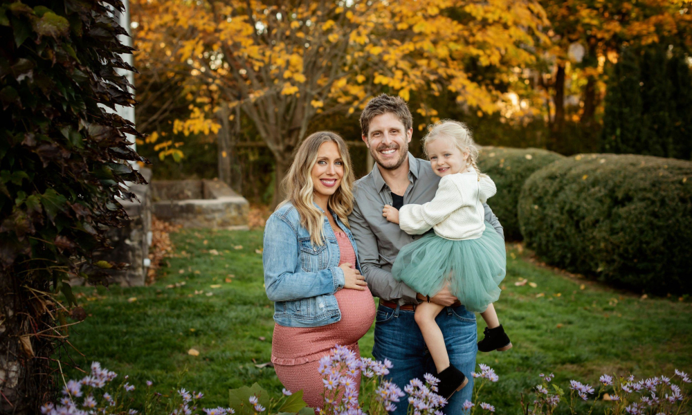 mom and dad with their daughter in the garden