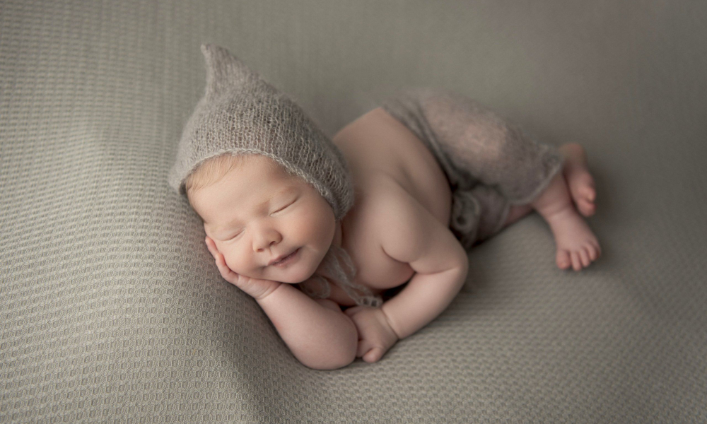 Newborn baby in dark gray hat