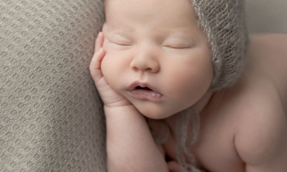 Newborn baby sleeping while opening own mouth