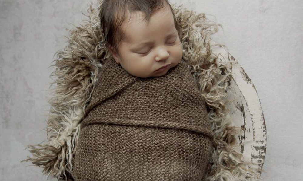 Newborn baby in brown wrap