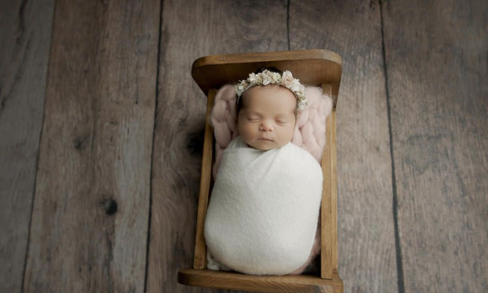 Newborn baby sleeping crib in white wrap