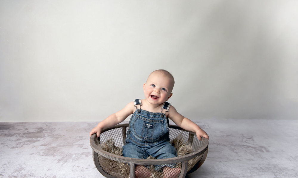 Milestone baby boy sitting in basket