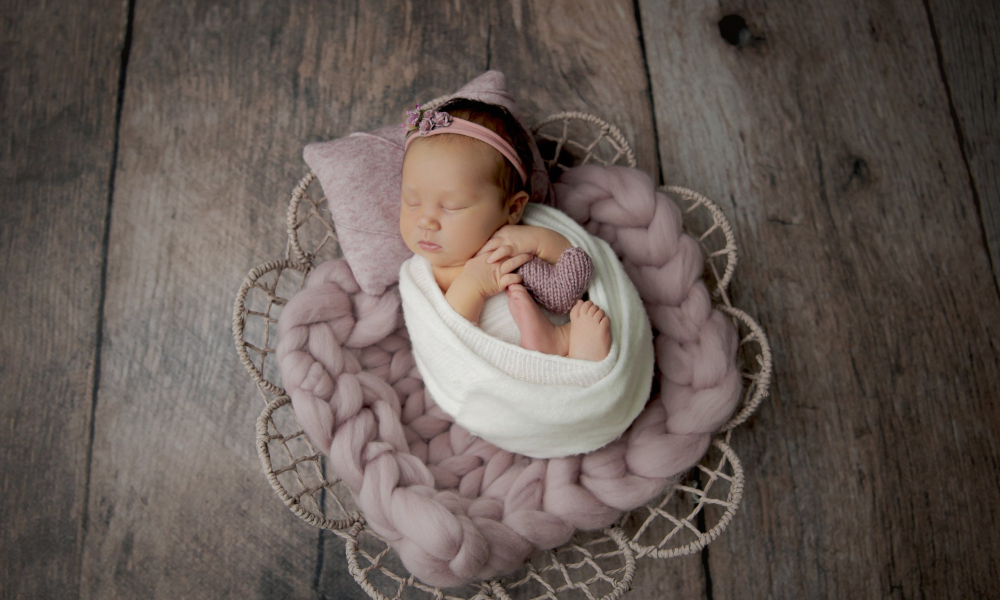 Newborn baby sleeping on white wrap