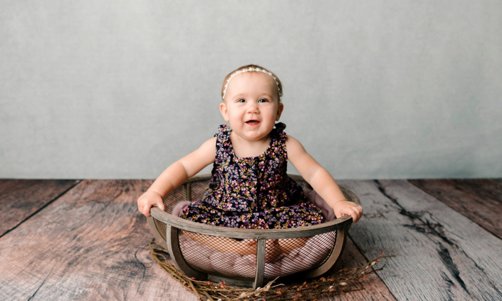baby girl milestone sitter session in the basket smiling lansdale