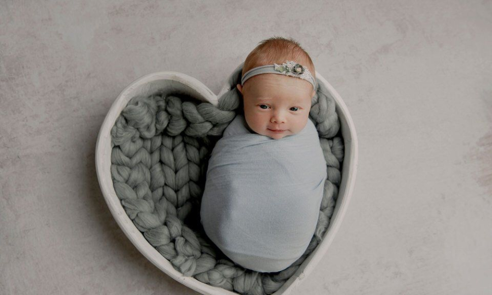 Newborn baby looking at the camera in white wrap