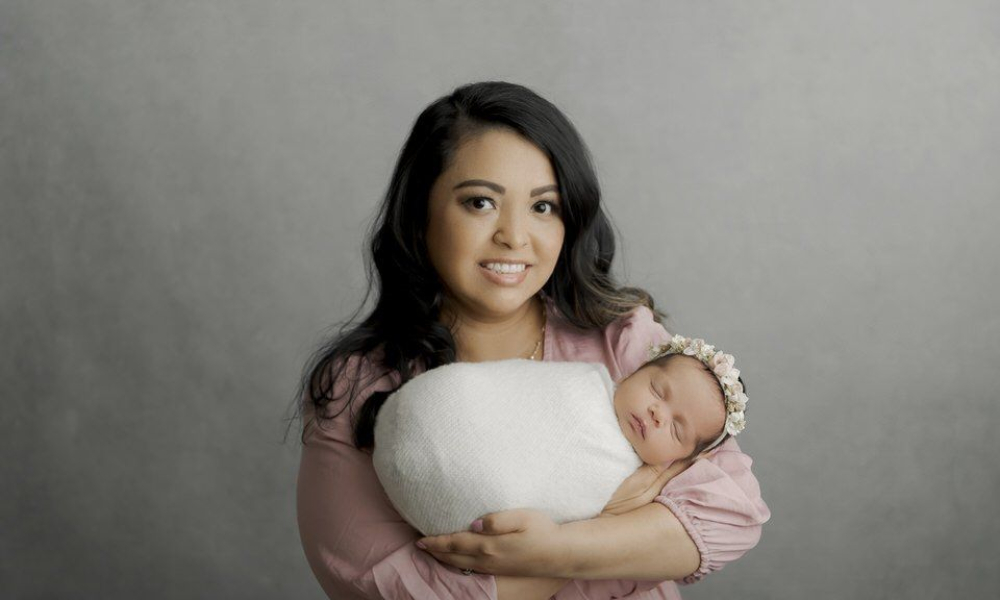 Mom holding newborn girl in white wrap